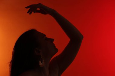 Kırmızı gradyan arkaplanda poz veren kadın silueti, metin için boşluk