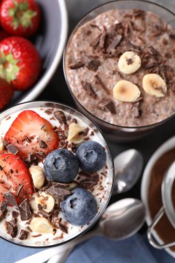 Chia tohumlu, fındıklı ve böğürtlenli lezzetli çikolatalı pudingler gri masada, düz yerde.