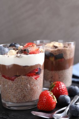 Chia tohumlu, fındıklı ve meyveli lezzetli çikolatalı pudingler masada, yakın plan.