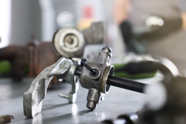 Otomobil parçası. Kapalı alandaki gri masada elle iletim.