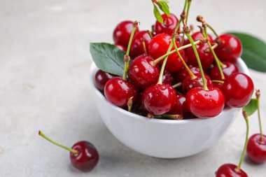 Islak olgun kirazlar ışık masasında, yakın plan.