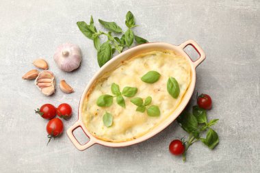 Lezzetli vejetaryen lazanyası ve gri masadaki malzemeler.