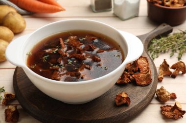 Mantarlı lezzetli çorba ve kraker hafif ahşap masada, yakın plan.