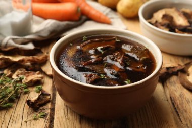 Mantarlı lezzetli çorba ve ahşap masada kekik, yakın plan.