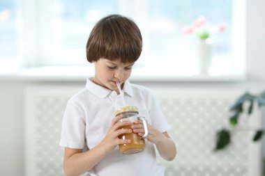 Evde portakal suyu içen tatlı bir çocuk. Tazeleyici içecek.