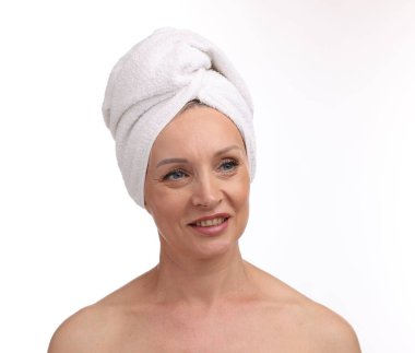 Beyaz arka planda kafasına havlu sarılmış güzel bir kadın.