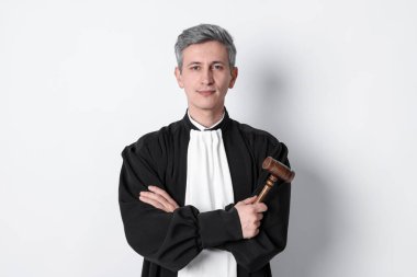 Hafif arka planda tokmak olan mahkeme elbiseli yargıç.