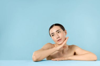 Açık mavi arka planda spa tedavisinden sonra güzel bir kadın. Metin için boşluk