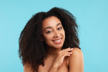 Açık mavi arka planda spa tedavisinden sonra güzel Brezilyalı kadın portresi