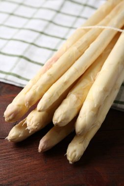 Ahşap masada çiğ kuşkonmaz mızrakları, yakın plan.