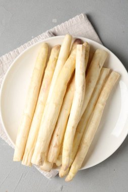 Gri desenli masa üzerinde çiğ beyaz kuşkonmaz mızrakları.