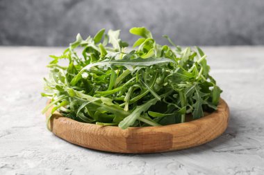 Taze yeşil roka yaprakları gri masada, yakın plan.