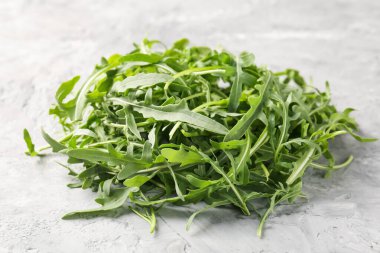 Taze yeşil roka yaprakları gri masada, yakın plan.