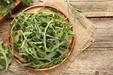 Taze yeşil roka yaprakları ahşap masada, düz yerde. Metin için boşluk