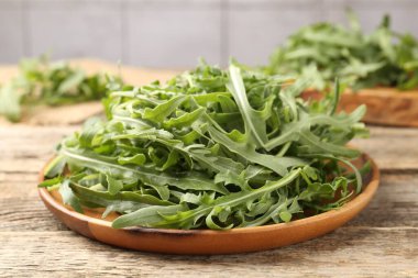 Taze yeşil roka yaprakları ahşap masada, yakın plan.