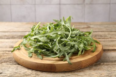 Taze yeşil roka yaprakları ahşap masada, yakın plan.