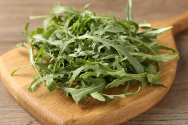 Taze yeşil roka yaprakları ahşap masada, yakın plan.