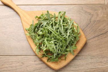 Taze yeşil roka yaprakları ahşap masanın üstünde, üst tarafta.