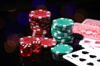 Kumarhane çipleri, ayna yüzeyinde kağıt ve zar oynamak bulanık ışıklara karşı, yakın plan