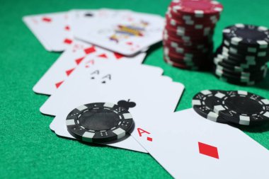 Kumarhane fişleri ve iskambil kartları yeşil masada, yakın plan