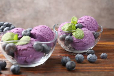 Ahşap masada servis edilen yaban mersinli ve naneli şerbet, yakın plan.