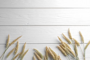 Beyaz ahşap masada bir sürü buğday çivisi var. Metin için boşluk
