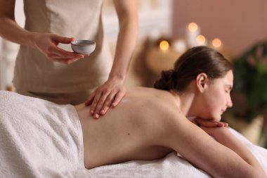 Spa salonunda kadın sırt masajı yaptırıyor.