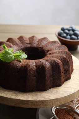 Naneli çikolatalı kek ve ahşap masada yaban mersini, yakın plan.