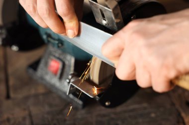 Bıçak keskinleştiren adam içeride, yakın plan.