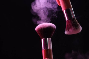 Siyah arkaplanda renk farlı makyaj fırçaları, yakın plan