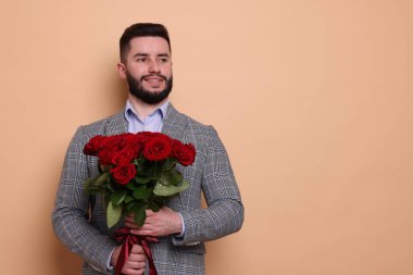 Bej arka planda kırmızı gül buketi olan mutlu adam, metin için boşluk.