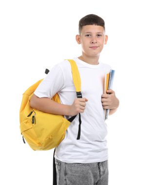 Not defterleri ve beyaz arka planda sırt çantası olan genç bir çocuk.