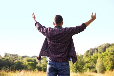 Özgürlüğü hissetmek. Adam dışarıda eğleniyor, arka manzara