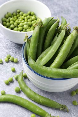 Gri masada taze taze taze bezelyeler, yakın plan.