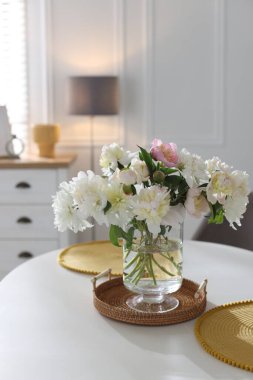 Yemek odasında bir vazo çiçekli güzel bir masa.