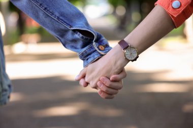 Parkta birlikte yürüyen sevimli çift, yakın plan.