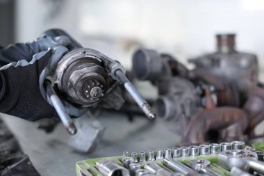 Otomobil parçaları. Kapalı bir masada başlangıç motoru olan profesyonel bir tamirci, yakın plan. Metin için boşluk