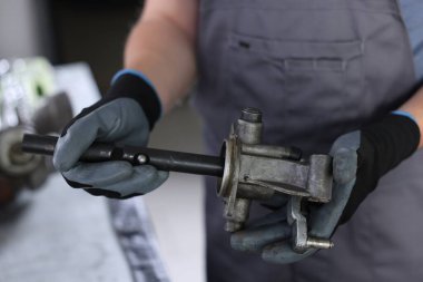 Otomobil parçası. Kapalı mekanda elle şanzıman yapan profesyonel bir tamirci.