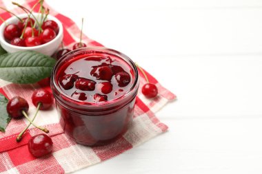 Lezzetli vişne reçeli ve beyaz masada taze meyveler, yakın plan. Metin için boşluk