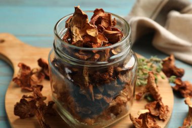 Mavi ahşap masadaki kekik mantarlı kurumuş chanterelle mantarları.