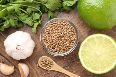 Taze kişniş, kişniş tohumu, kireç ve sarımsak ahşap masada, düz yatıyordu.