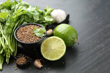 Koyu dokulu masada kişniş tohumları taze kişniş, kireç ve sarımsak, yakın plan. Metin için boşluk