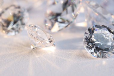 Işıklı arka planda pek çok parlak elmas, yakın plan