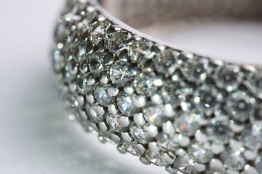 Işıklı arka planda parlak elmasları olan güzel bir yüzük, makro manzara.