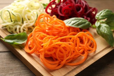 Ahşap masada fesleğenli farklı sebze erişteleri, yakın plan. Vejetaryen yemeği.