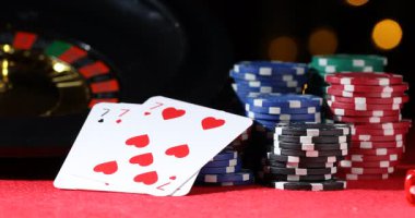 Kumarhane fişleri kırmızı masaya düşüyor bulanık ışıklara karşı, yakın plan