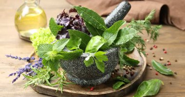 Tahta masada farklı taze otları harca serp, yakın plan.