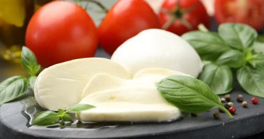 Masadaki mozzarella peynirine baharat ekliyorum. Yakın plan.