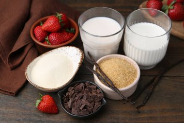 Panna cotta için farklı malzemeler. Süt, şeker, vanilya, çikolata ve çilek ahşap masada, yakın plan.