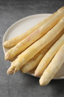 Gri desenli masada çiğ beyaz kuşkonmaz mızrakları, yakın plan.